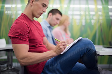 Image showing male student taking notes in classroom