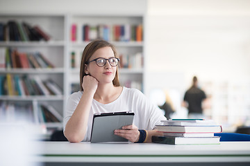 Image showing female student study in school library, using tablet