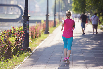 Image showing sporty woman running  on sidewalk