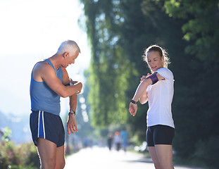 Image showing jogging couple planning running route  and setting music