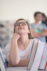 Image showing portrait of famale student selecting book to read in library