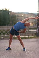 Image showing handsome man stretching before jogging