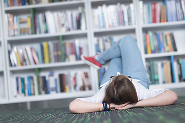 Image showing female student study in library, using tablet and searching for 