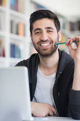 Image showing student in school library using laptop for research