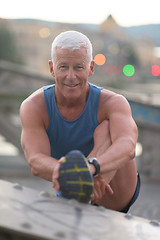 Image showing handsome man stretching before jogging