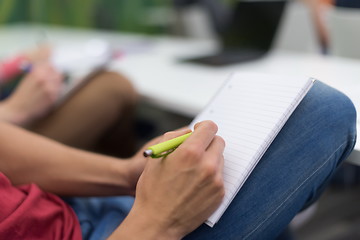 Image showing male student taking notes in classroom