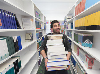 Image showing Student holding lot of books in school library