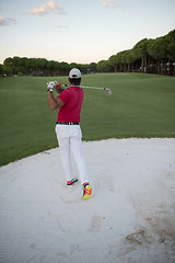 Image showing golfer hitting a sand bunker shot on sunset