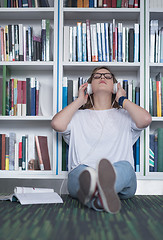 Image showing female student study in library, using tablet and searching for 