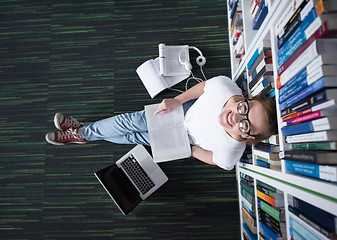 Image showing female student study in library, using tablet and searching for 