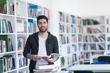 Image showing portrait of student while reading book  in school library