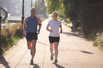 Image showing couple warming up and stretching before jogging