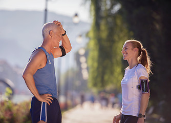 Image showing jogging couple planning running route  and setting music