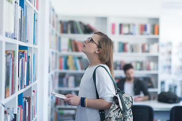 Image showing famale student selecting book to read in library