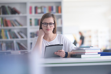 Image showing female student study in school library, using tablet