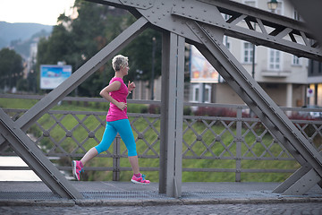 Image showing sporty woman running  on sidewalk