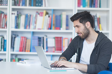 Image showing student in school library using laptop for research