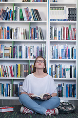 Image showing famale student reading book in library