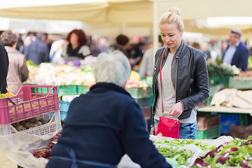 Image showing Woman buying vegetable at local food market. 