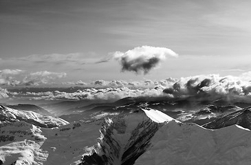 Image showing Black and white winter mountains at evening and sunlight clouds