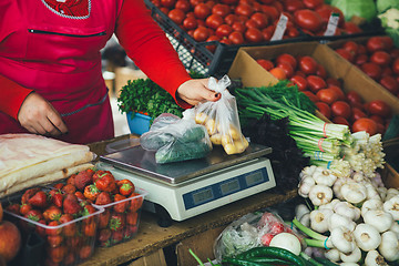 Image showing the seller is weighing vegetables on scales