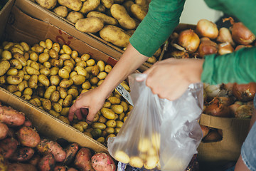 Image showing woman puts a package of new potatoes on the market