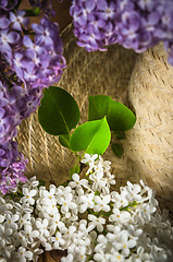 Image showing Still-life with a bouquet of lilacs and a straw hat, close-up