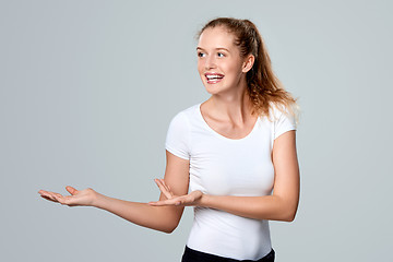 Image showing Smiling woman showing open hand palm with copy space
