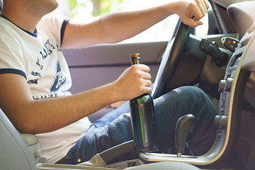 Image showing Man drinking beer while driving the car.