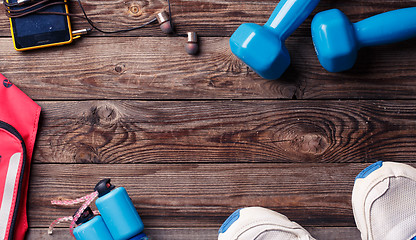 Image showing Sports equipment - sneakers, skipping rope, dumbbells, smartphone and headphones. 