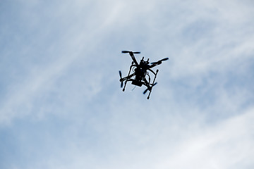 Image showing flying drone with camera on the sky