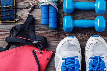 Image showing Shoes and sports equipment on wooden floor, top view