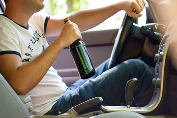 Image showing Man drinking beer while driving the car.