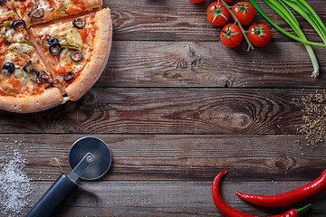 Image showing Tasty pizza with ingridients on a wooden board.