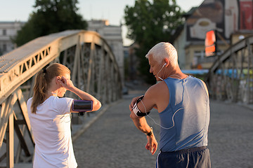 Image showing jogging couple planning running route  and setting music