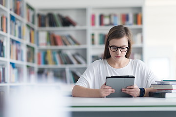 Image showing female student study in school library, using tablet