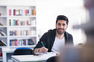 Image showing student in school library using laptop for research