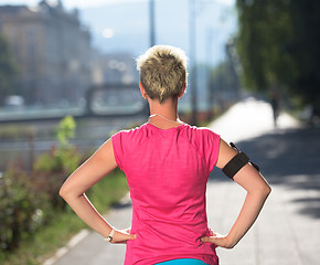 Image showing jogging woman setting phone before jogging