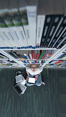 Image showing female student study in library, using tablet and searching for 