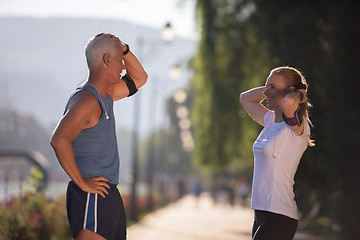 Image showing jogging couple planning running route  and setting music