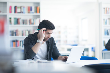 Image showing student in school library using laptop for research