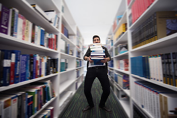 Image showing Student holding lot of books in school library