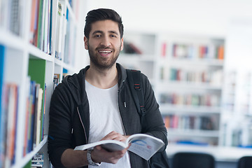 Image showing portrait of student while reading book  in school library