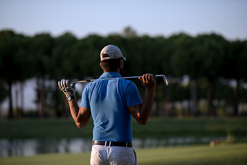 Image showing golfer from back at course looking to hole in distance