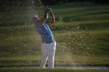 Image showing golfer hitting a sand bunker shot on sunset