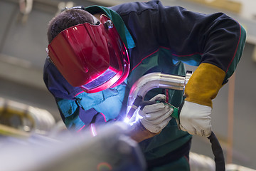 Image showing Industrial worker welding in metal factory.