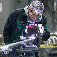 Image showing Industrial worker setting orbital welding machine.