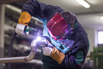 Image showing Industrial worker welding in metal factory.