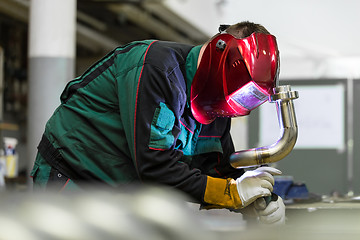 Image showing Industrial worker welding in metal factory.