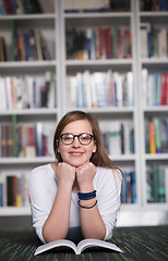 Image showing female student study in library, using tablet and searching for 